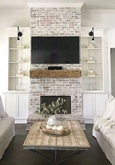 a living room with two couches and a television mounted on the wall above it