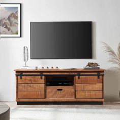 a flat screen tv mounted to the side of a wooden entertainment center in a living room