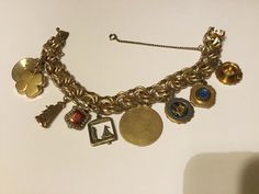 Beautiful 12kt gold filled charm bracelet with 9 charms and safety clasp. Woven links.size 7.5 inches. Charm #1- gold tone tea cup and saucer, #2- 1/20 10kt  Mount Mary College,#3- 1/20 10kt Milwaukee Wisconsin,#4- 1/20 12kt Florida Souvenir,#5- Moveable Sail Boat,#6- possibility a sorority charm ,#7- 1/20 12kt Dane craft Windmill,#8-four leaf clover and #9- Anniversary Pin. In great pre owned condition. Craft Windmill, 9 Anniversary, Mount Mary, 9th Anniversary, Milwaukee Wisconsin, Sail Boat, Jewelry Lookbook, Tea Cup And Saucer, Leaf Clover