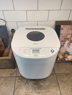 a white bread maker sitting on top of a kitchen counter next to a cookbook