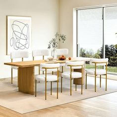 a dining room table with white chairs and a painting on the wall in front of it