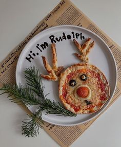 a white plate topped with pizza covered in toppings and an animal face made out of bread sticks