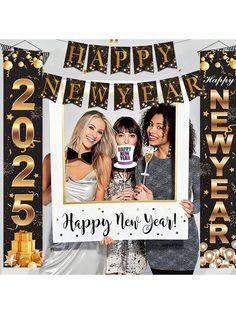 two women standing next to each other in front of a happy new year photo booth