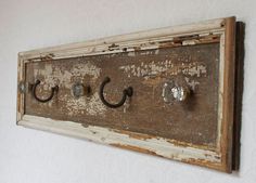 an old wooden coat rack with four knobs and three hooks on the front wall