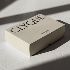 an open box sitting on top of a white surface with the word clique written in black