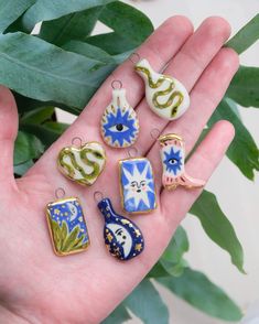 a person's hand holding several small ceramic ornaments