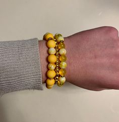 Beautiful trio of bracelets comprised of bright yellow, clear yellow, yellow marble and gold beads. The largest beads are 10mm. The clear and marble yellow beads are 8mm round glass beads. The smaller beads are 5mm iron round beads. The bracelets are approximately 17-17.5 cm in length each. Yellow Beaded Bracelet, Beaded Jewelry Bracelets, Diy Beaded Bracelets, Bracelet Sets, Beaded Bracelets Tutorial, Bracelets Design, Bracelet Display, Beads Bracelet Design, Wrist Wear