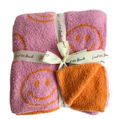 two towels wrapped in pink and orange with smiley faces on them