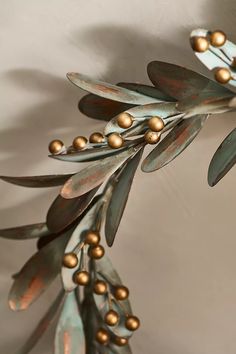 a close up of a metal plant with gold balls on it's leaves and branches