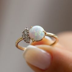 The 14k Gold White Opal Ring, known for promoting tranquility and stimulating creativity, also serves as October's birthstone. The ring is crafted from 14k solid gold. Accompanying the opal are cubic zirconia stones. This beautiful ring is ideal for those with sensitive skin as it is hypoallergenic. You can choose from white gold, yellow gold, or rose gold. Additionally, if you prefer a natural opal instead of the synthetic opal in this design, we can make that change for you. Please note that a Opal Birthstone Ring In White Gold, Classic White Opal Ring With Birthstone, Classic White Opal Birthstone Ring, White Opal Birthstone Ring In 14k Gold, 14k Gold White Opal Birthstone Ring, White Opal Birthstone Ring With Gemstone, Heirloom White Opal Ring Oval Cabochon, Heirloom White Opal Ring, Fine Jewelry White Opal Birthstone Ring