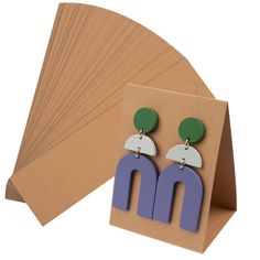 PRICES MAY VARY. HIGH QUALITY - Our Earring Display Cards are made of high quality paper material with pre-cut holes and pre-scored which are very easy to use. SIZE - Each standing earring card measures 6.5 x 5 x 8.5 cm/2.6 x 2 x 3.4 Inch. UNIQUE DESIGN - These display cards are the perfect gift for anyone who needs to display their earrings vertically. They stand securely on the table without the use of a display stand. EASY TO OPERATE - Each earring card is pre-scored so it's easy to fold, ass Earring Display Cards, Jewelry Display Cards, Earring Display Stands, Laser Cut Earrings, Earring Card, Paper Earrings, Packaging Supplies, Earring Holder, Paper Material