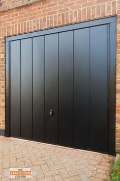 a black garage door on a brick building