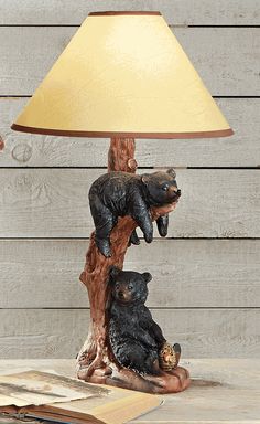 the bear lamp is next to an open book on a table with a yellow shade