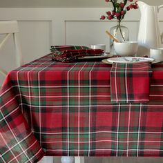 the table is set with red, green and white plaid cloths on it's placemats