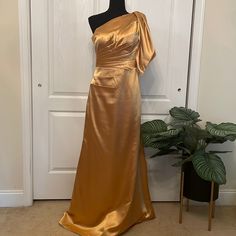 a mannequin is standing next to a gold dress