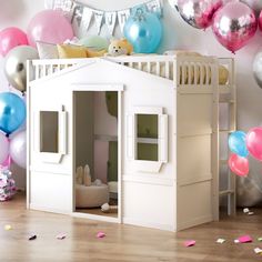 a doll house with balloons and streamers in the background