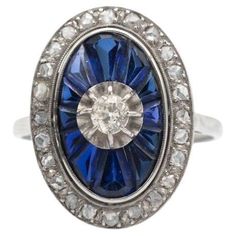 Beautiful old cluster ring made of white gold and platinum. Its central point is a diamond in an old brilliant cut weighing approx. 0.20ct. An old oval-shaped ring decorated with faceted sapphires in a carre cut and numerous diamonds in a rose cut. Origin: France, 1920s-1930s. Preserved hallmark "eagle head". Dimensions of the decorative element: 21mm x 15mm Weight: 4.5g. Ring size: 19 (59) - possible size correction. Gemmological laboratory certificate included