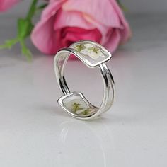 Resin ring meticulously crafted using real flowers and fully cured UV resin. The flowers silver ring is inspired by the graceful charm of Boho jewelry. This white silver band  is a perfect meaningful gift for a beloved woman, and as a pampering gift for yourself. The jewelry is very flattering, lightweight, comfortable to wear as jewelry for everyday use and impressive as jewelry for a special occasion. Each piece is individually crafted to order, ensuring a unique touch, with subtle variations that make every piece truly one-of-a-kind. Elevate your style with this exceptional jewelry- a wearable piece of art designed for your enjoyment. Purchase now for an exquisite blend of nature and craftsmanship. Special Features: - Handmade with real flowers, fully cured UV resin  - Flowers colors : Handmade Delicate Toe Rings, Delicate Handmade Toe Rings, White Sterling Silver Nature-inspired Jewelry, Nature-inspired White Sterling Silver Jewelry, Handmade White Sterling Silver Stackable Rings, Handmade Sterling Silver Stackable White Rings, Delicate Silver Flower Ring, Handmade White Toe Ring, Adjustable Pressed Flowers Ring For Wedding