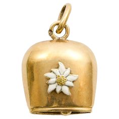 This large vintage 14-karat yellow gold Swiss cow bell charm pendant is a striking and unique piece of jewelry. It features a beautifully crafted white enameled edelweiss flower set prominently on the front of the bell, adding a touch of elegance and charm to the overall design. The gold bell is solid and substantial, with a smooth, polished surface that complements the delicate enamel work. The edelweiss, with its crisp white petals and yellow center, stands out as a symbolic and decorative ele Stella Alpina, Swiss Cow, Edelweiss Flower, White Petals, Cow Bell, Bell Pendant, The Alps, Enamel Charms, Gold Enamel