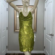 a mannequin dressed in a green sequin dress