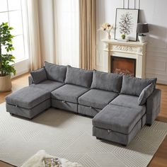 a living room with a large gray sectional couch and white rug in front of a fireplace