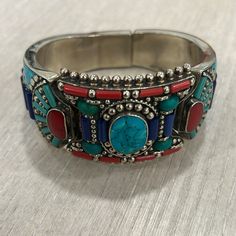 Vintage Tibetan Nepalese Cuff Bangle With Turquoise Coral And Lapis Lazuli Stone Good Condition Vintage Bohemian Blue Cuff Bracelet With Natural Stones, Blue Bohemian Cuff Bracelet With Natural Stones, Blue Bangle Cuff Bracelet With Natural Stones, Blue Natural Stones Bangle Cuff Bracelet, Bohemian Multi-stone Cuff Bracelet As Gift, Bohemian Multicolor Gemstone Cuff Bracelet, Bohemian Blue Gemstone Cuff Bracelet, Blue Gemstone Bohemian Cuff Bracelet, Blue Cuff Bracelet With Natural Stones