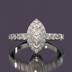 an engagement ring with a pear shaped diamond in the center and pave set shoulders