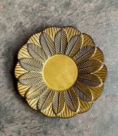 a yellow and black plate sitting on top of a cement floor next to a wall