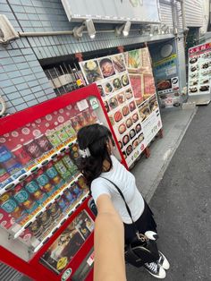 a woman sitting on the ground in front of a food stand