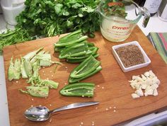 chopped up green vegetables on a cutting board next to a measuring cup and spoons