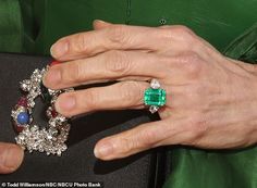 an older woman's hand holding two rings and a ring on top of her finger