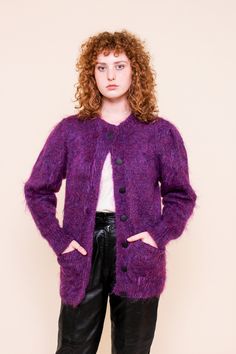 This vibrant knit cardigan features black buttons down the front, two open front pockets in a super soft fuzzy purple wool blend. Measurements: Bust 42", Waist 36", Length 30" Material: 78% Mohair, 13% wool, 9% Nylon Brand: Anncraft Care: Hand wash, dry flat Condition: Excellent Purple Long Sleeve Cardigan For Winter, Purple Long Sleeve Cardigan With Button Closure, Purple Long Sleeve Winter Cardigan, Purple Long Sleeve Sweater Coat For Fall, Purple Wool Sweater For Winter, Purple Wool Winter Sweater, Purple Button-up Cardigan With Buttons, Purple Button-up Cardigan, Purple Button-up Cardigan For Fall