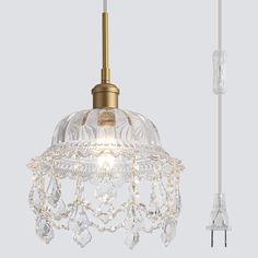 a light that is hanging from the ceiling with a cord attached to it and some glass beads