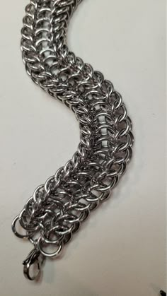 a silver chain is shown on a white surface