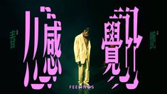 a man standing on top of a stage in front of pink and green text that says feelings