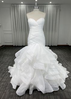 a white wedding dress on display in front of a window