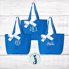 three personalized tote bags with white bows and monogrammed names on them