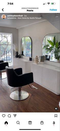 a hair salon with chairs and mirrors on the wall, in front of two windows