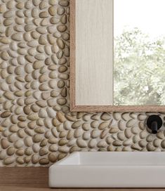 a bathroom sink sitting under a mirror in front of a wall mounted faucet