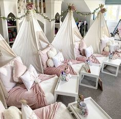 a room filled with lots of white furniture and pink bedspreads covered in blankets