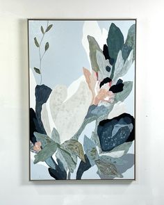 a painting hanging on the wall next to a vase with flowers and leaves in it