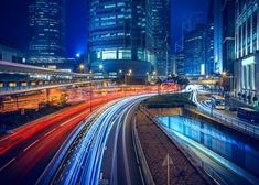 the city is lit up at night with long exposures and street lights in motion