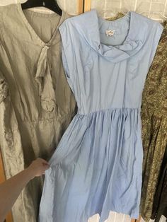 Lot of 4 1950’s dresses1. Light blue cotton dress, has underarm discoloration. Bust 39” waist 27” hips free2. Green paisley, major sun fading, see photos. 42” bust 28” waist hips free3. Grey linen dress, small stains throughout. 50” bust 40” waist 48” hips4. Green and brown cotton paisley striped dress. Missing all but two buttons. Bust 36” waist 25” hips free.All being sold as is, will need repairs Vintage Blue Summer Dress, Blue 1950s Style Summer Dress, 1950s Style Blue Summer Dress, 1950s Blue Summer Dress, Vintage Light Blue Knee-length Dress, Blue Cotton Vintage Dress For Summer, Blue Cotton Vintage Summer Dress, Light Blue Sleeveless Vintage Dress, Blue Vintage Summer Dress