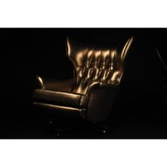 a black leather chair in the dark with its foot rest up against it's back