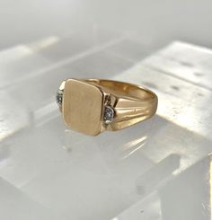 Art Deco 10Kt men's soft square signet ring  with small Diamonds on shoulders size 8.25 SKU-1982 A classic signet ring with a soft square face, and grooved and tapered shoulders. The ring has 2 small single cut accent Diamonds, one on each shoulder framing the ring nicely. This men's ring is ready to be personalized with your initial(s) by the goldsmith or engraver of your choice. D E T A I L S : Measures     :   Ring size 8.25 Diamonds    :   2 single cut approx. combined weight .03 Carat Weigh Classic Rectangular Signet Ring Stamped 14k, Heirloom Rectangular Signet Ring Stamped 14k, Classic Rectangular 14k Stamped Rings, Vintage Rectangular Diamond Ring For Gift, Vintage Rectangular Diamond Ring Gift, Vintage Rectangular Signet Ring With Polished Finish, Classic 14k Stamped Diamond Ring, Vintage Gold Rectangular Rings, Vintage Rectangular Gold Rings