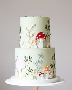 a three tiered cake with mushrooms on it