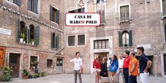 a group of people standing in front of a building with a sign that says casca di marco poloo