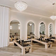 an empty gym with benches and mirrors in the center, surrounded by white curtains on either side