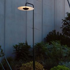 an outdoor lamp in front of a building