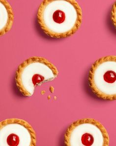 several desserts with cherry topping on pink background